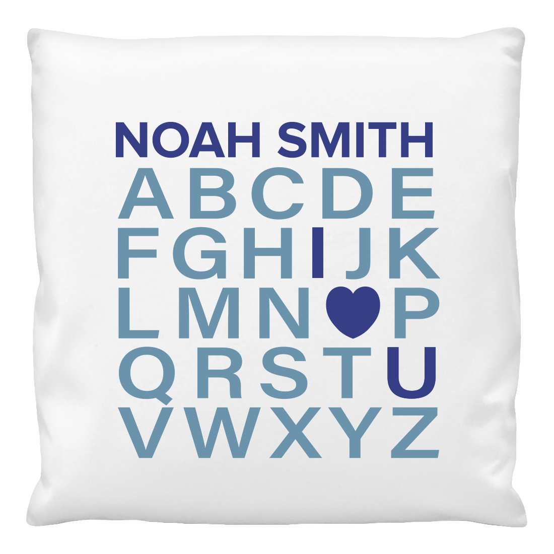 A white cushion cover with the text 'NOAH SMITH' and the alphabet from 'A' to 'Z', with a heart symbol replacing the letter 'I', printed in blue.