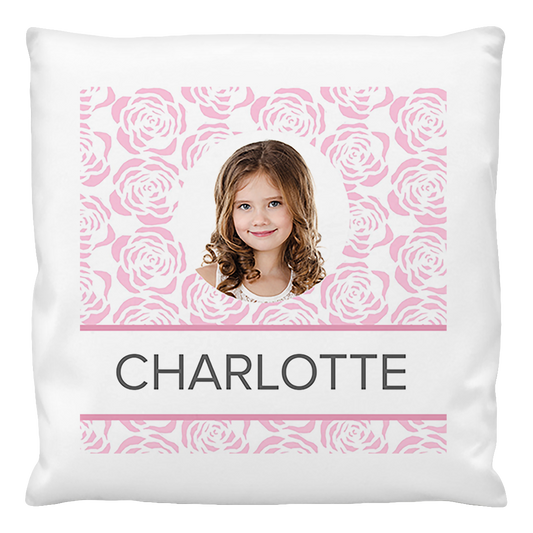 A custom photo cushion cover featuring a printed photo of a girl named Charlotte, with a pink roses pattern in the background.