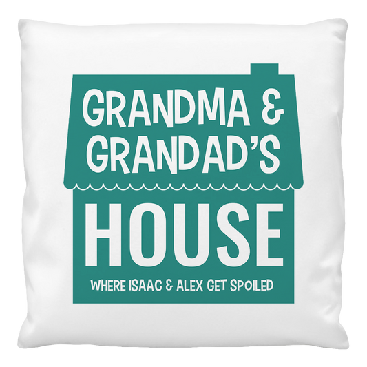 A white cushion cover with the text 'GRANDMA & GRANDPAS'S HOUSE WHERE ISAAC & ALEX GET SPOILED' printed in green.